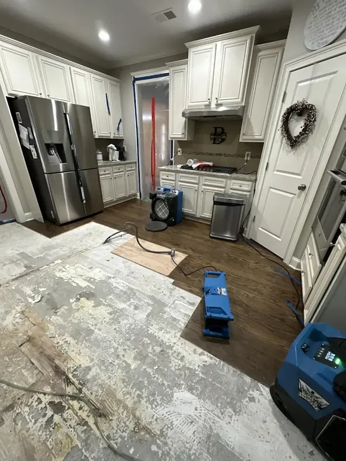 Dehumidifier and air mover drying a kitchen floor in Duluth
